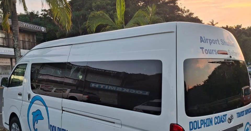 The Dolphin Coast Tourist Services mini-bus, lettered for airport shuttles and tours, at sunset