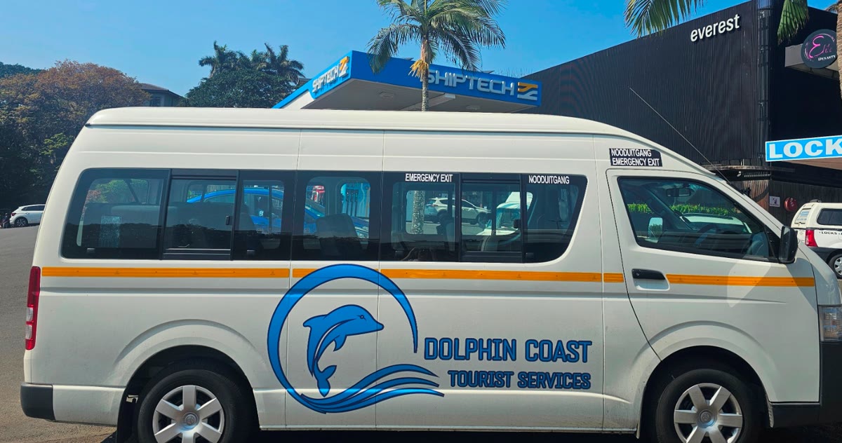 The fifteen-seater Dolphin Coast Tourist Services mini-bus parked under palms in Ballito